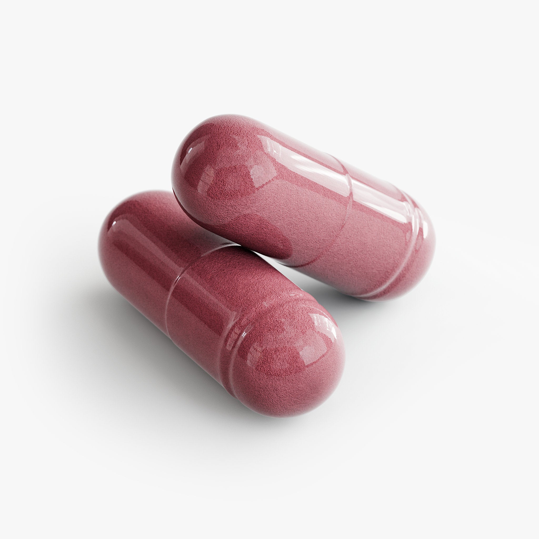 Two pink capsules on a white background