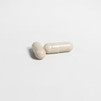 Two beige ceramic items resembling capsules on a light gray background