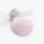 White scoop filled with pink powder on a white background