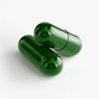 Two green capsules on a white background