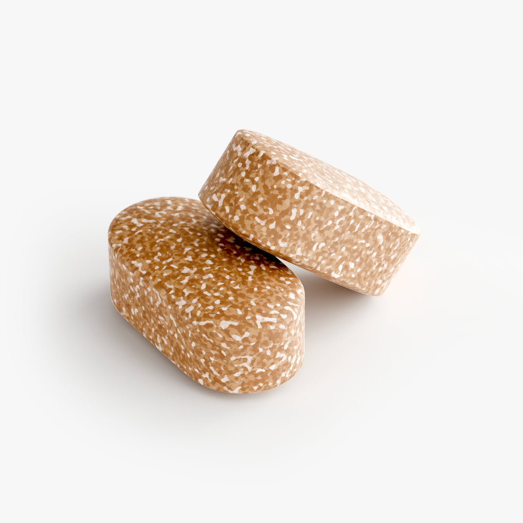 Two brown speckled tablets on a white background