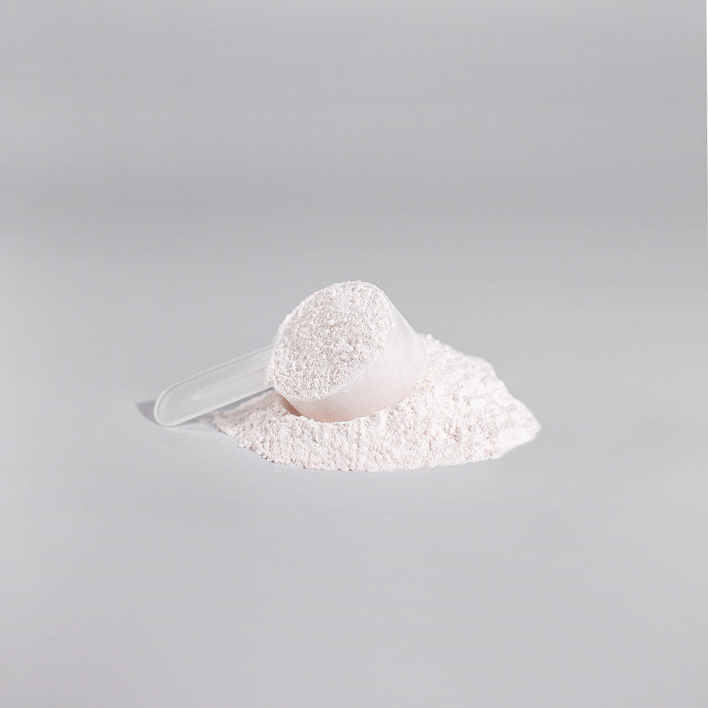 White powder in a scoop on a gray background