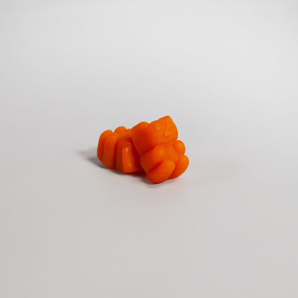 Orange gummy candy on a light gray background