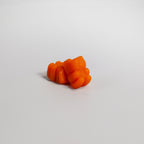 Orange gummy candy on a light gray background
